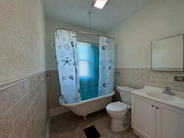 a bathroom with a toilet sink vanity and shower