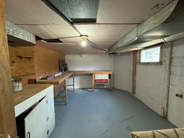 a utility room with stainless steel appliances kitchen island granite countertop a sink and cabinets