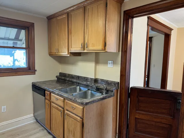 a kitchen with stainless steel appliances granite countertop a sink and a wooden cabinets