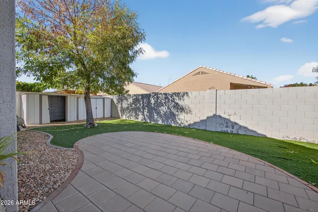 a view of a house with a yard and a large tree