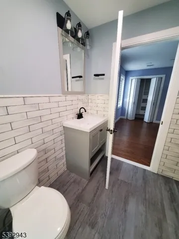 a bathroom with a granite countertop toilet a sink a mirror and a shower