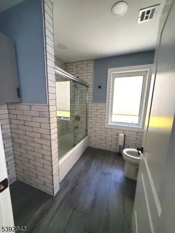 a view of a room with a ceiling fan and wooden floor