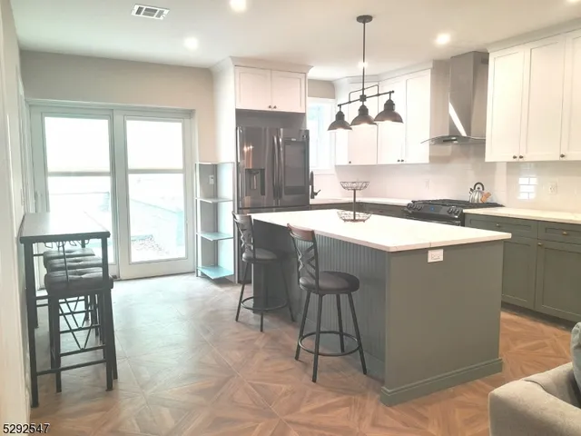 a kitchen with stainless steel appliances granite countertop a sink a stove and a refrigerator