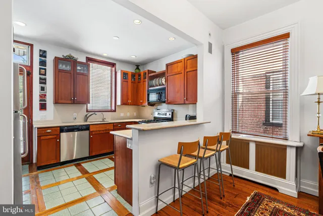 a kitchen with stainless steel appliances granite countertop sink stove top oven and cabinets