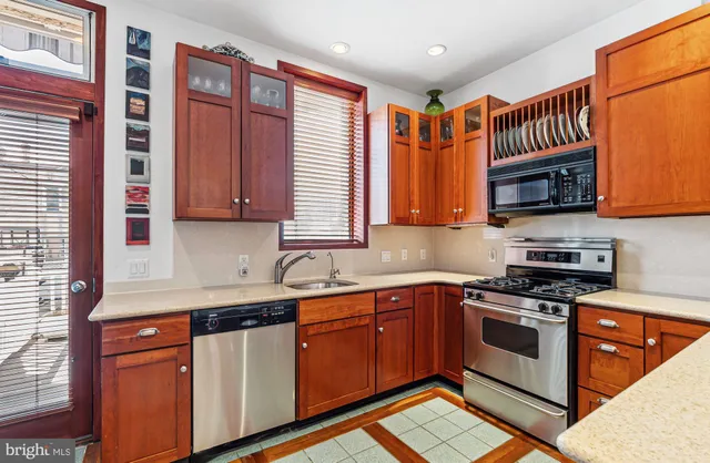 a kitchen with stainless steel appliances granite countertop wooden cabinets a sink and a stove