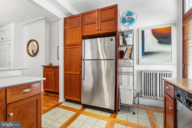 a view of a refrigerator and a stove with wooden floor