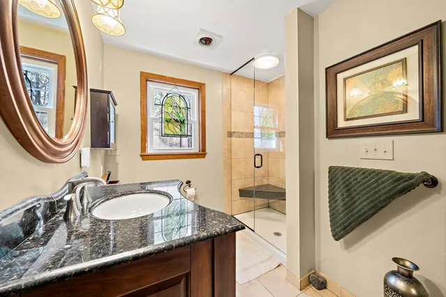 a bathroom with a granite countertop sink and a mirror