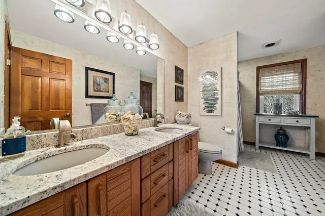 a bathroom with a sink double vanity granite and a mirror
