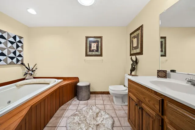 a spacious bathroom with a granite countertop sink and a bathtub