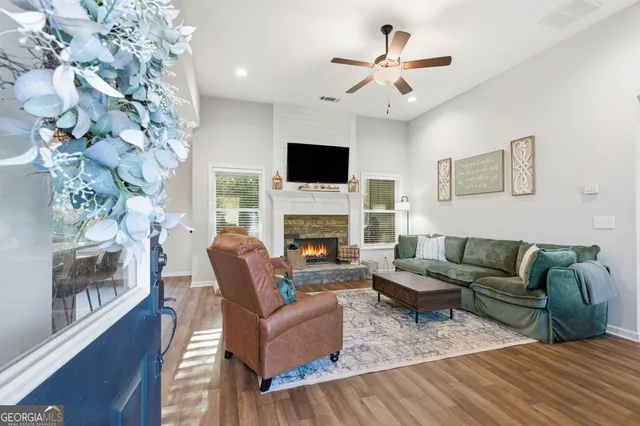 a living room with furniture a flat screen tv and a fireplace