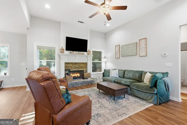a living room with furniture a flat screen tv and a fireplace