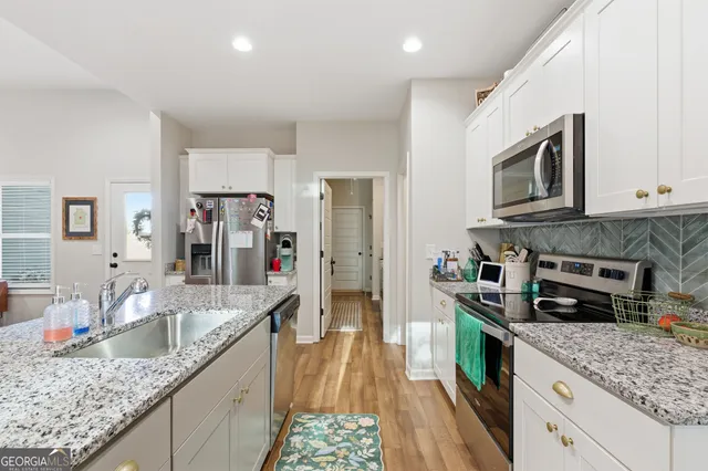 a kitchen with stainless steel appliances granite countertop a sink stove and refrigerator