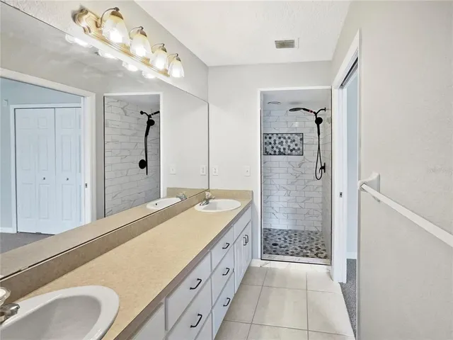 a spacious bathroom with a granite countertop sink a mirror and a shower