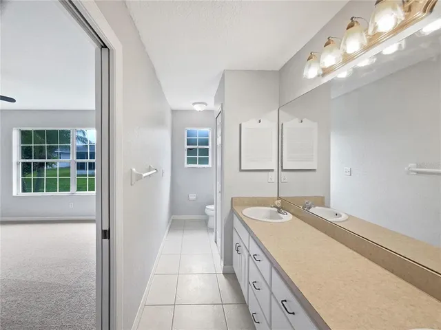a view of a kitchen with refrigerator and white cabinets
