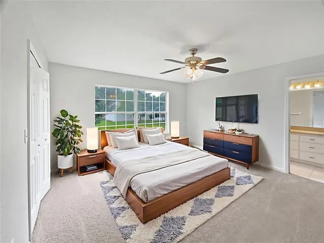 a bedroom with a bed potted plant on dresser and a chandelier