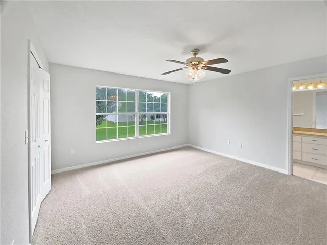 a view of a room with a ceiling fan and a window