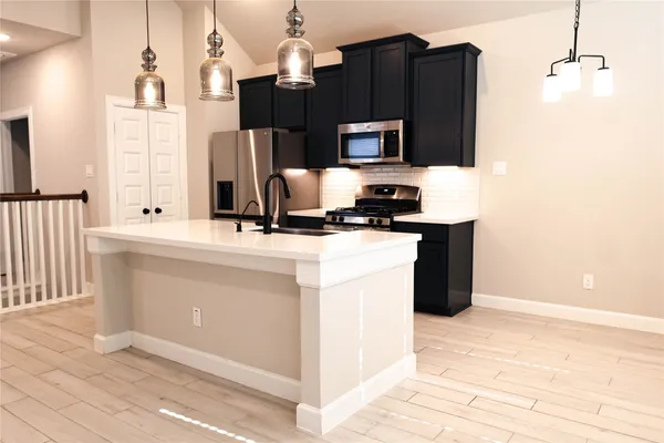 a kitchen with a sink microwave and refrigerator