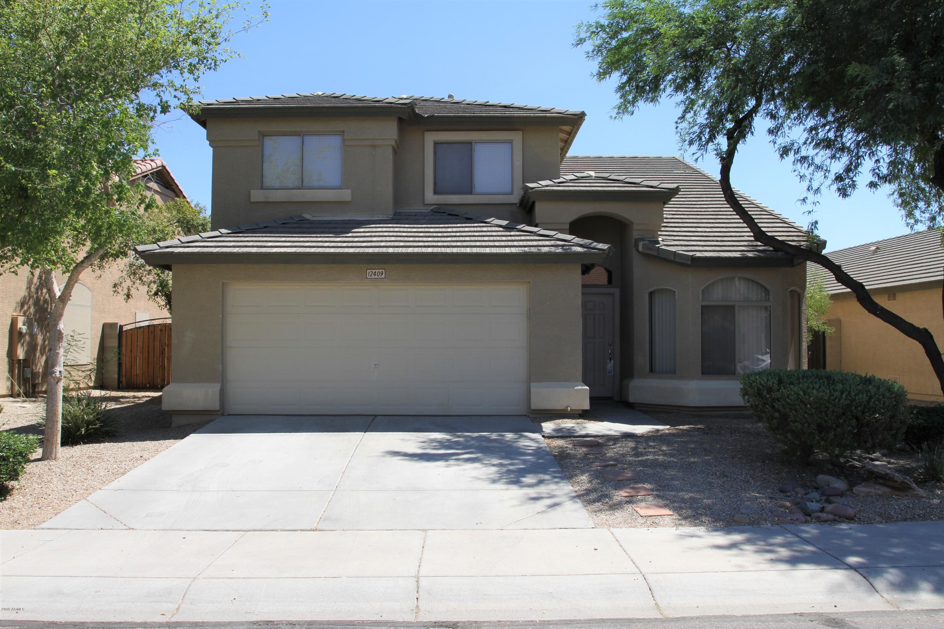 12409 West San Juan Avenue Litchfield Park, AZ 85340 - Photo 1 of 12 a front view of a house with garage
