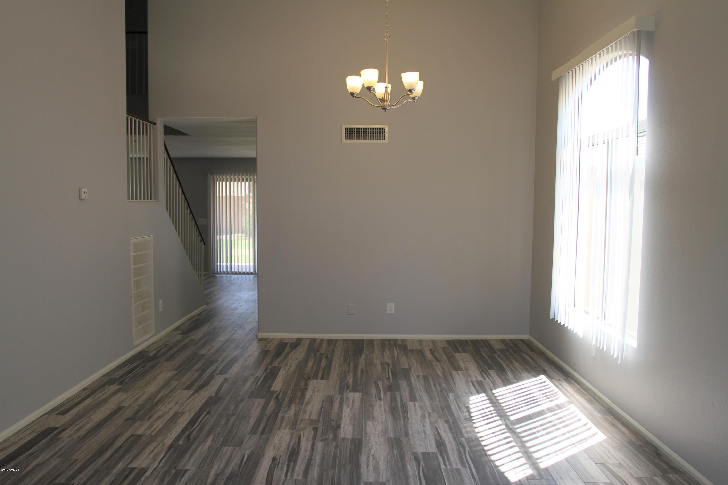 12409 West San Juan Avenue Litchfield Park, AZ 85340 - Photo 2 of 12 wooden floor in an empty room with a window