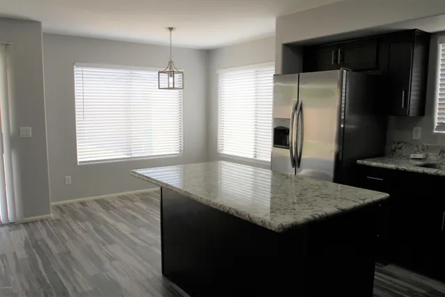 a kitchen with kitchen island a counter top space appliances and a window