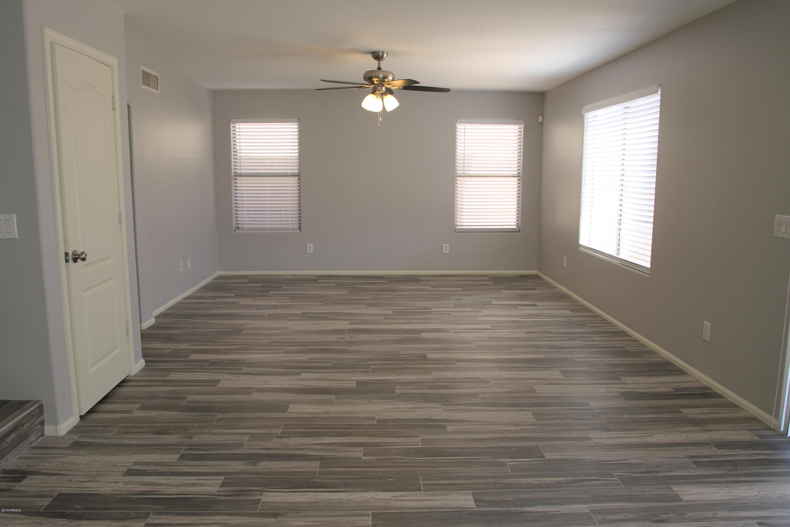 12409 West San Juan Avenue Litchfield Park, AZ 85340 - Photo 6 of 12 a view of an empty room with wooden floor and a window