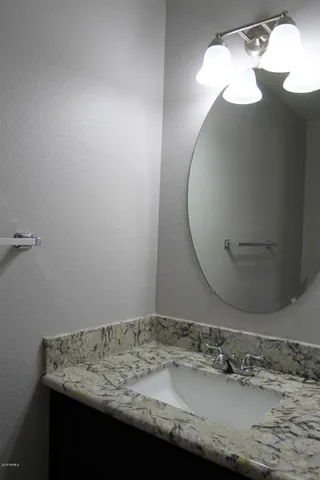 a bathroom with a granite countertop sink and mirror