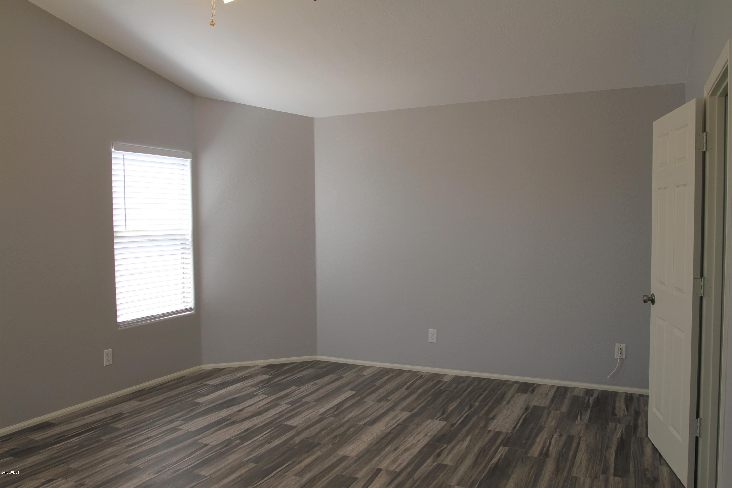 12409 West San Juan Avenue Litchfield Park, AZ 85340 - Photo 9 of 12 an empty room with wooden floor and windows