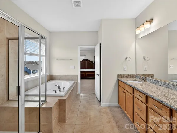 a bathroom with a granite countertop sink tub and mirror