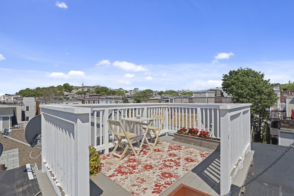 522 East 8th Street, Unit 3 Boston, MA 02127 - Photo 13 of 16 a view of a balcony with wooden chairs and floor to ceiling window