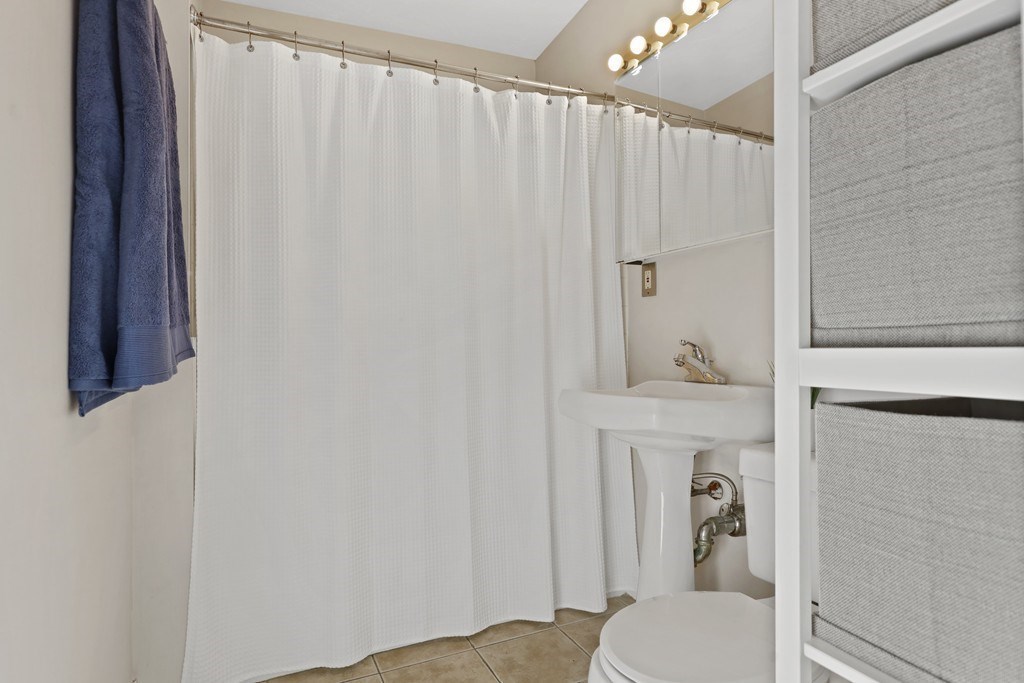 522 East 8th Street, Unit 3 Boston, MA 02127 - Photo 6 of 16 a bathroom with a sink a toilet and shower curtain