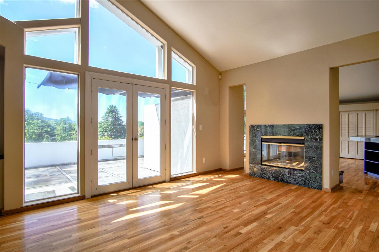 3435 Rio Road Carmel, CA 93923 - Photo 31 of 69 an empty room with wooden floor fireplace and windows