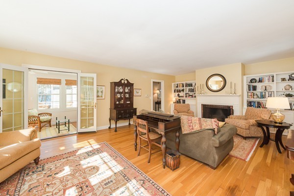18 Woodside Road Topsfield, MA 01983 - Photo 9 of 30 a living room with furniture a fireplace and a floor to ceiling window