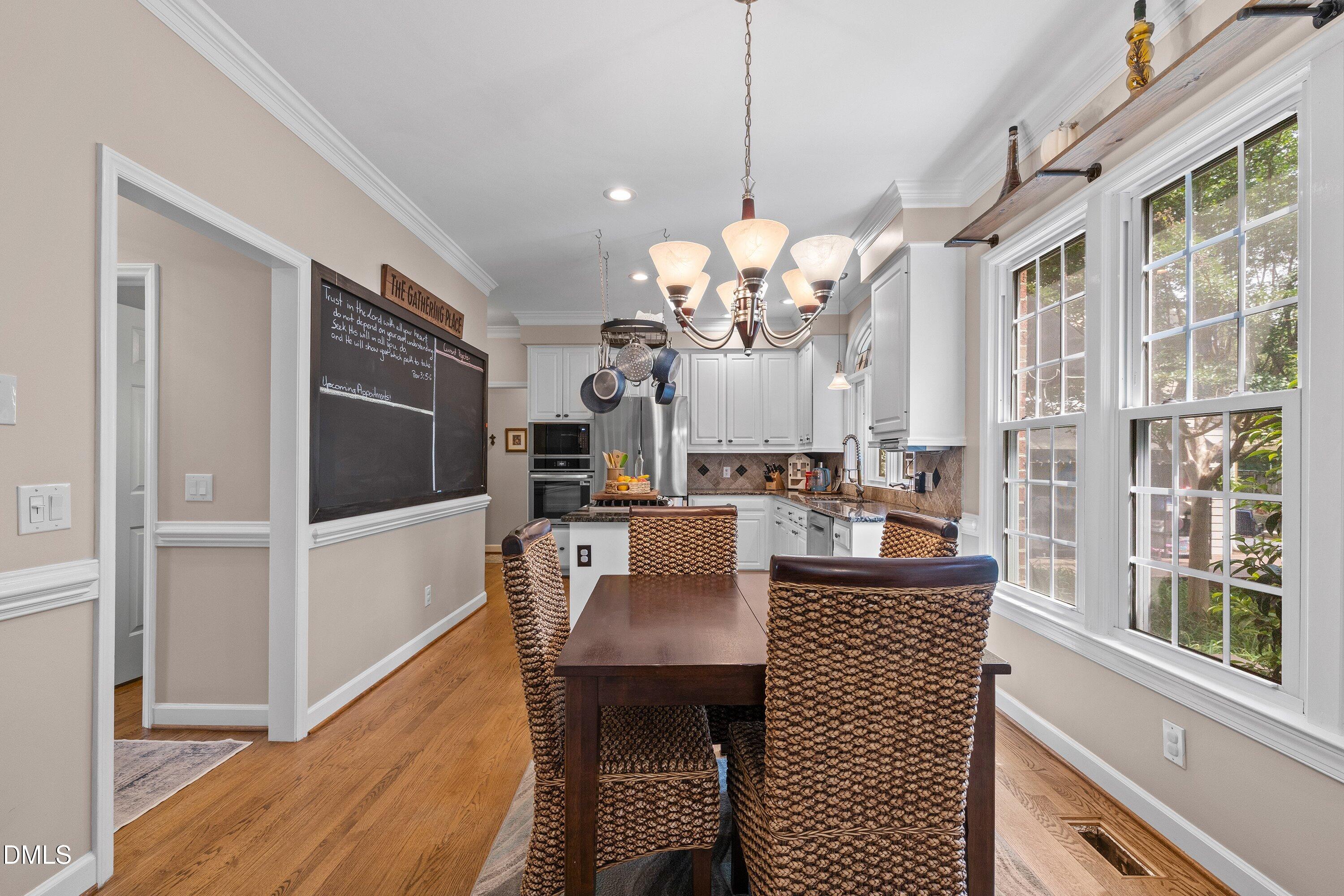 6612 Fowler Road Zebulon, NC 27597 - Photo 14 of 42 a view of a dining room with furniture a chandelier and wooden floor