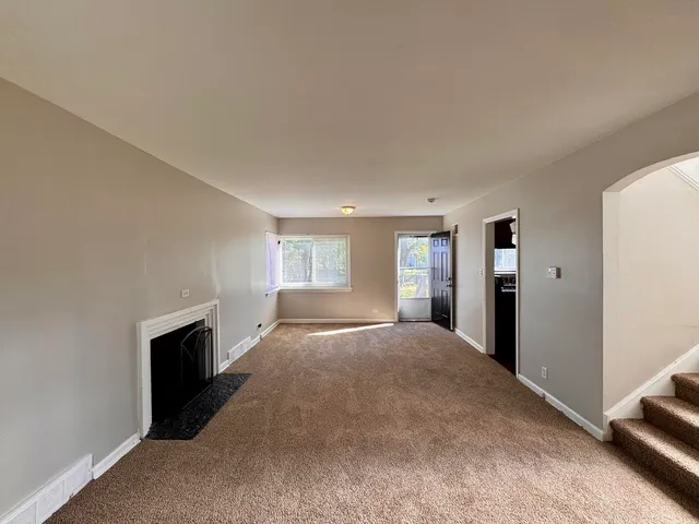 a view of an empty room with window and a bedroom