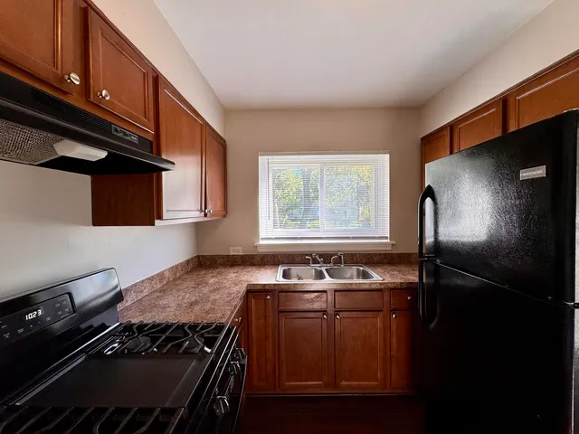 a kitchen with kitchen island granite countertop stainless steel appliances and a sink