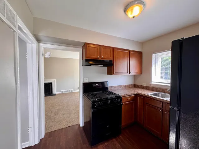 a kitchen with granite countertop stainless steel appliances a stove a sink and a microwave