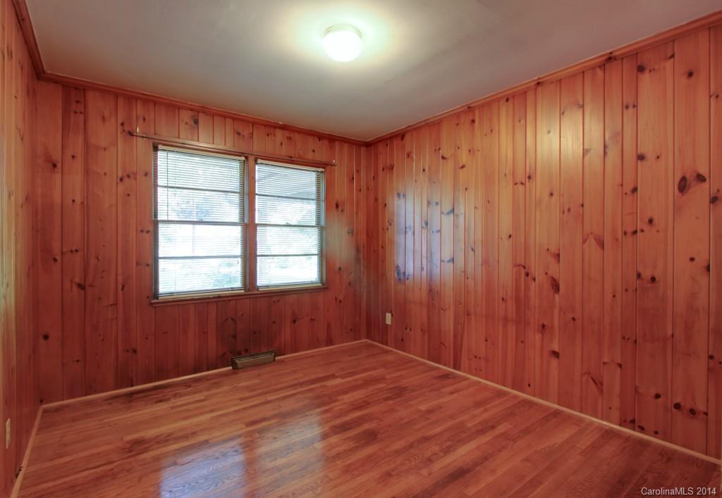 538 Scaleybark Road Charlotte, NC 28209 - Photo 12 of 20 an empty room with wooden floor and windows with curtains