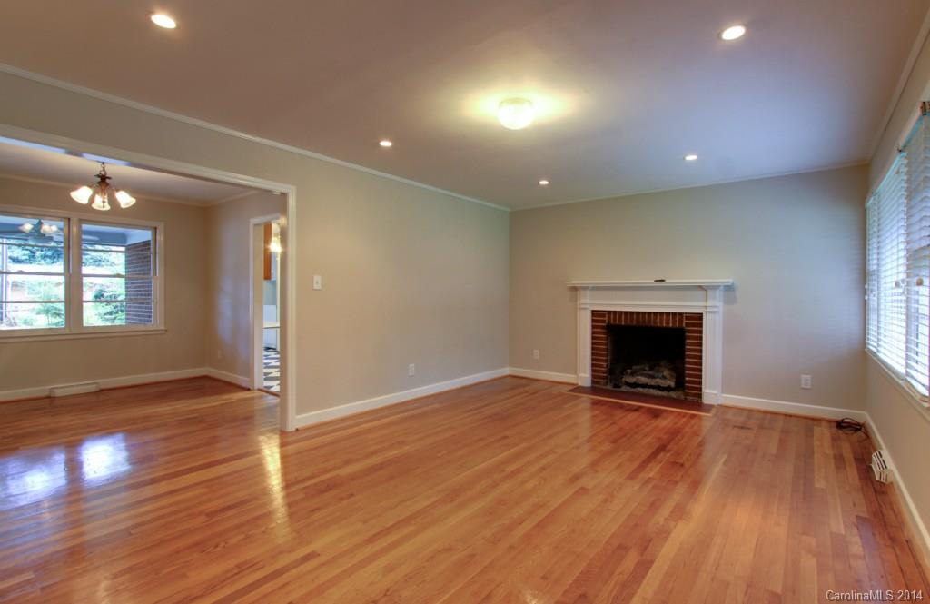 538 Scaleybark Road Charlotte, NC 28209 - Photo 4 of 20 an empty room with wooden floor fireplace and windows