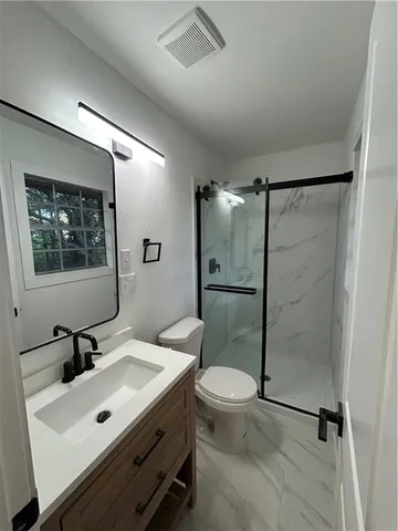 a bathroom with a sink mirror toilet and shower