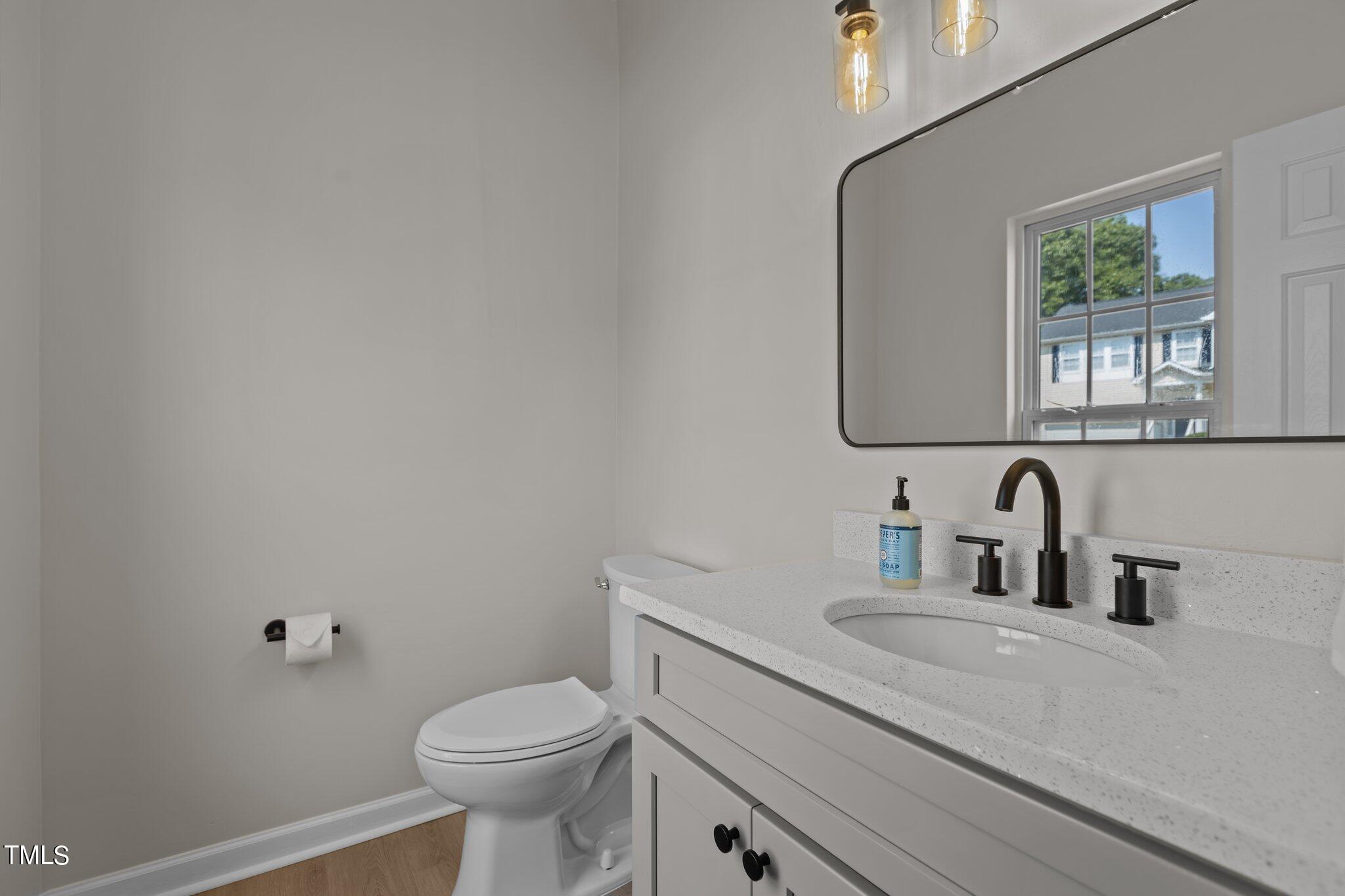 3225 Forest Mill Circle Raleigh, NC 27616 - Photo 13 of 36 a bathroom with a granite countertop toilet sink mirror and window