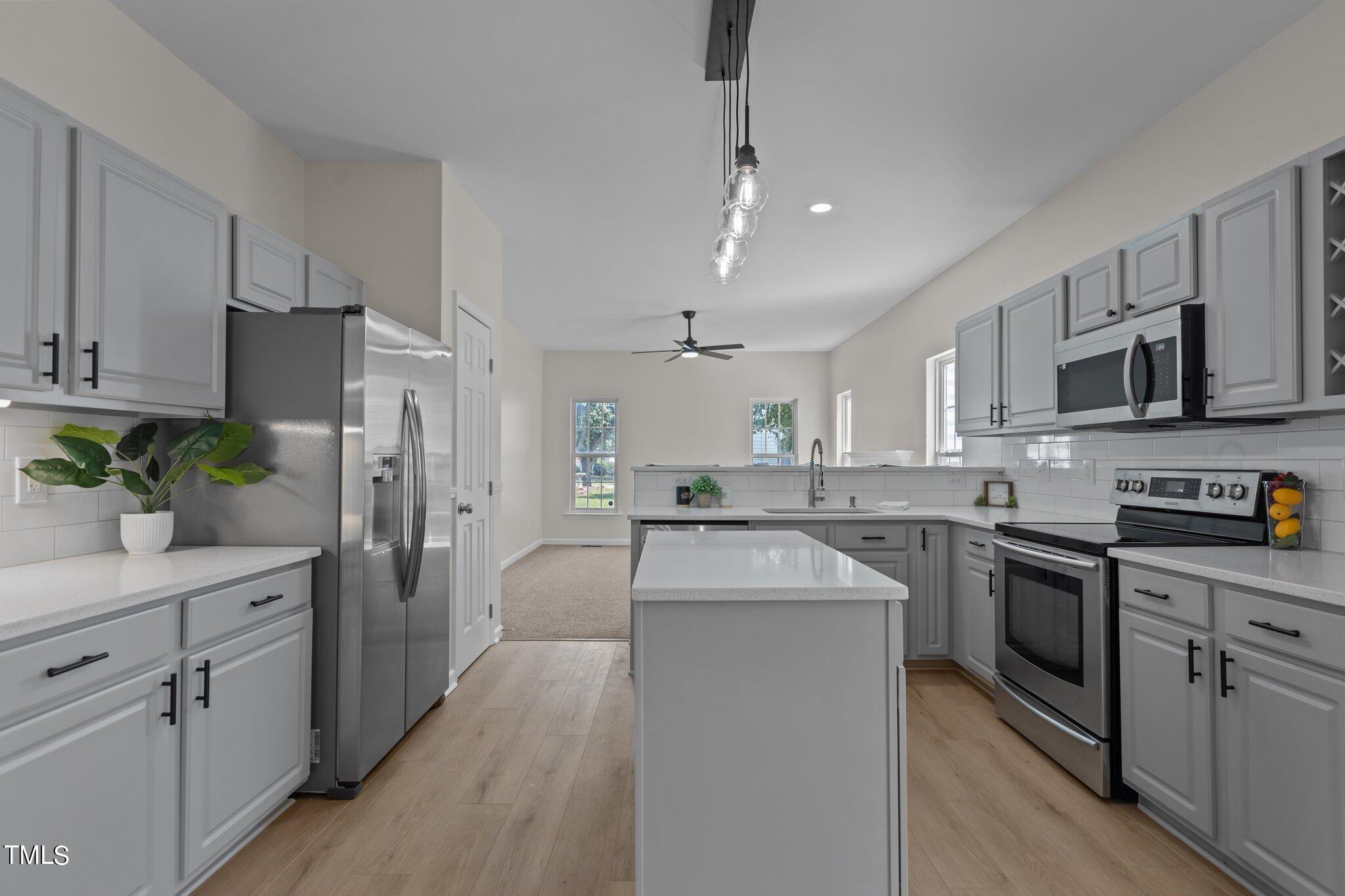 3225 Forest Mill Circle Raleigh, NC 27616 - Photo 6 of 36 a kitchen with white cabinets and stainless steel appliances