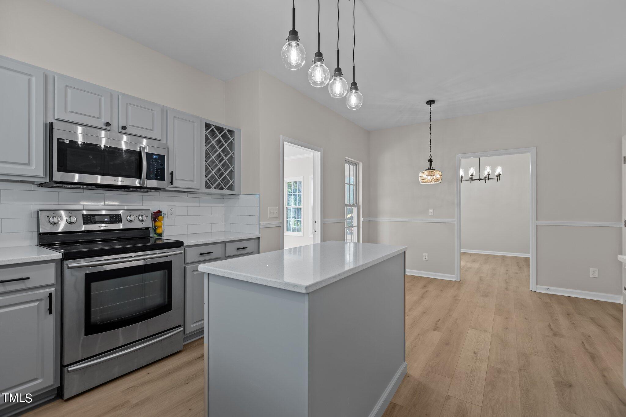 3225 Forest Mill Circle Raleigh, NC 27616 - Photo 8 of 36 a kitchen with stainless steel appliances a stove a microwave and a hard wood floor