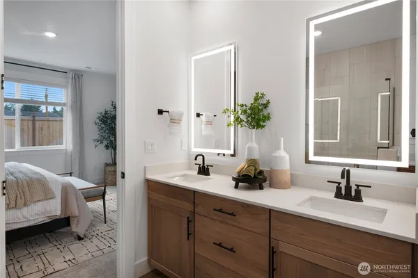 a bathroom with double vanity sink a window and a mirror