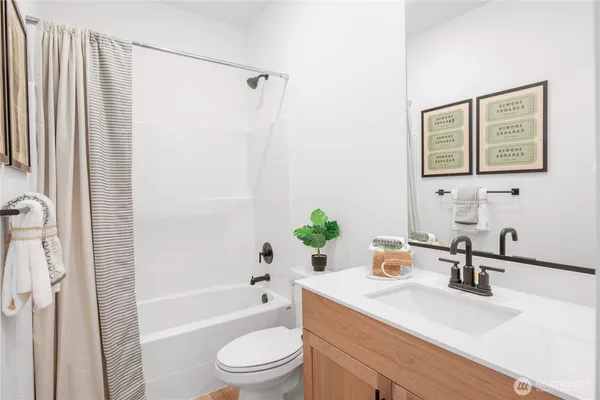 a bathroom with a sink a toilet a tub and shower