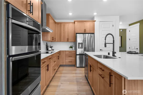 a large kitchen with stainless steel appliances granite countertop a sink and cabinets