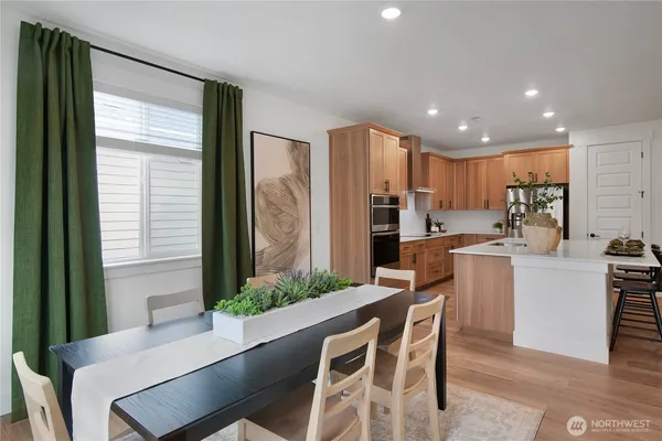 a kitchen with kitchen island a counter top space a sink stainless steel appliances and cabinets