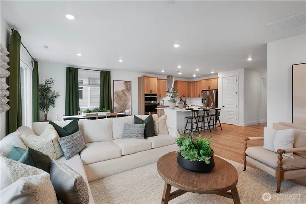 a living room with furniture kitchen and a large window