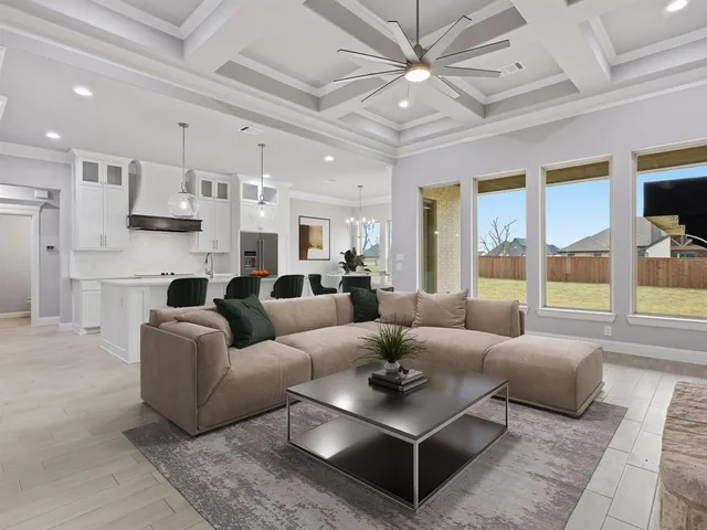 a living room with furniture kitchen view and a large window