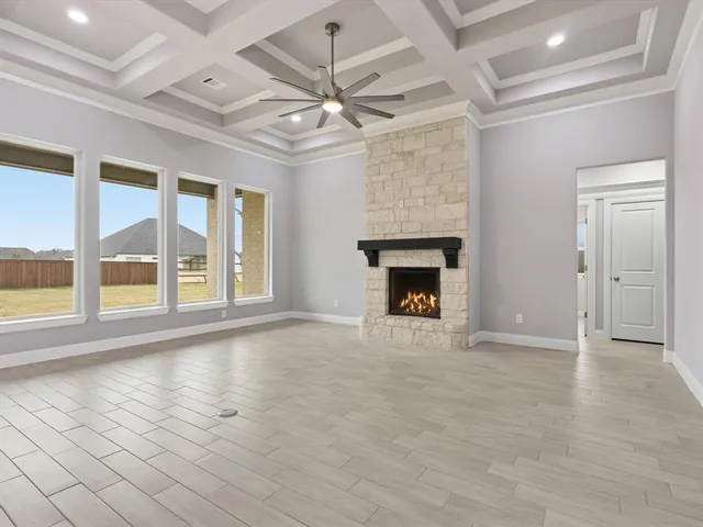 a view of an empty room with a fireplace and a window