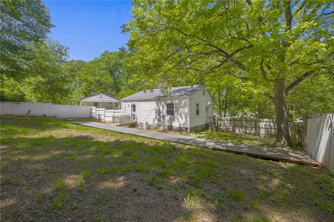 1616 Meadow Brook Circle Anderson, SC 29624 - Photo 20 of 24 This spacious backyard features a charming white home and a wooden walkway.